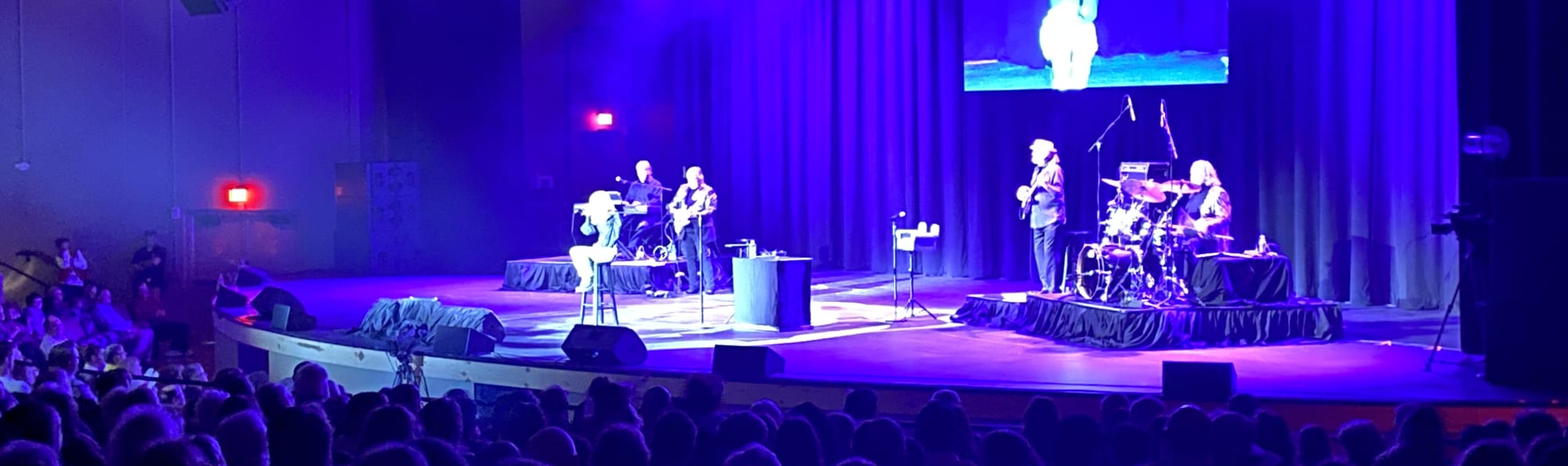 signer on stage in chair washed out by the lights Charlotte